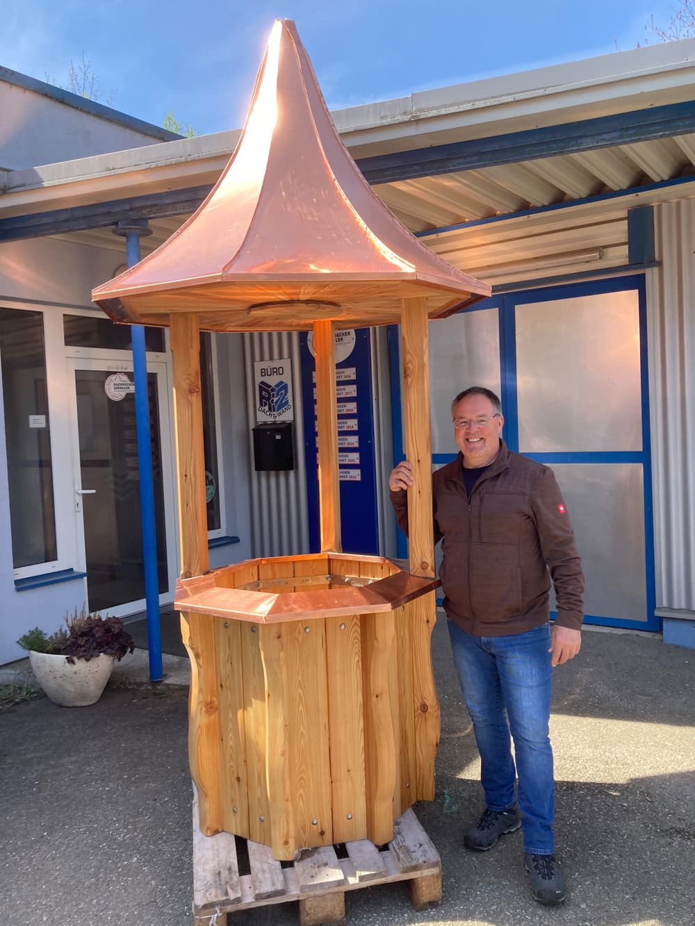 ein Mann steht neben einem hölzernen Whirlpool